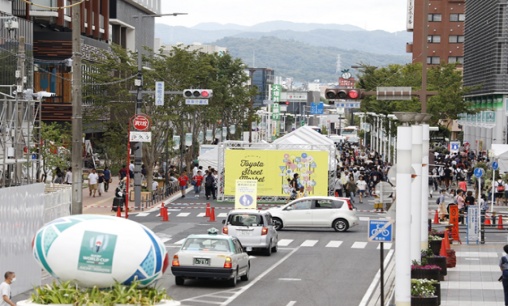 (駅前の大きな通りを完全に封鎖し、実施。出店は道路中央に位置し、緊急車両の通行幅の確保と(歩道の)歩行者にも見える配置。)